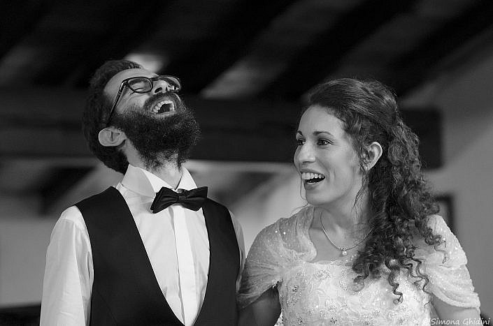 Servizio fotografico per matrimonio con risate degli sposi al ricevimento